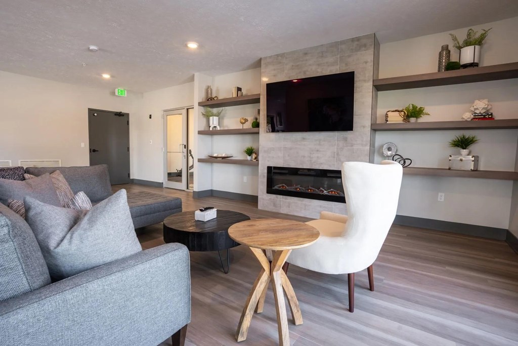 A grey couch sits in front of a fireplace in a modern living room.