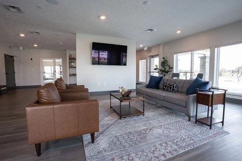 A living room with a brown leather chair and a grey sofa.