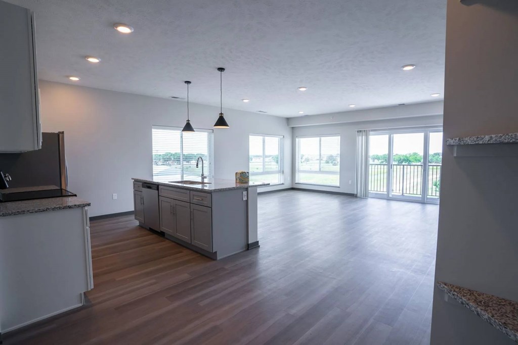 A kitchen with a wooden floor and a large island in the middle.
