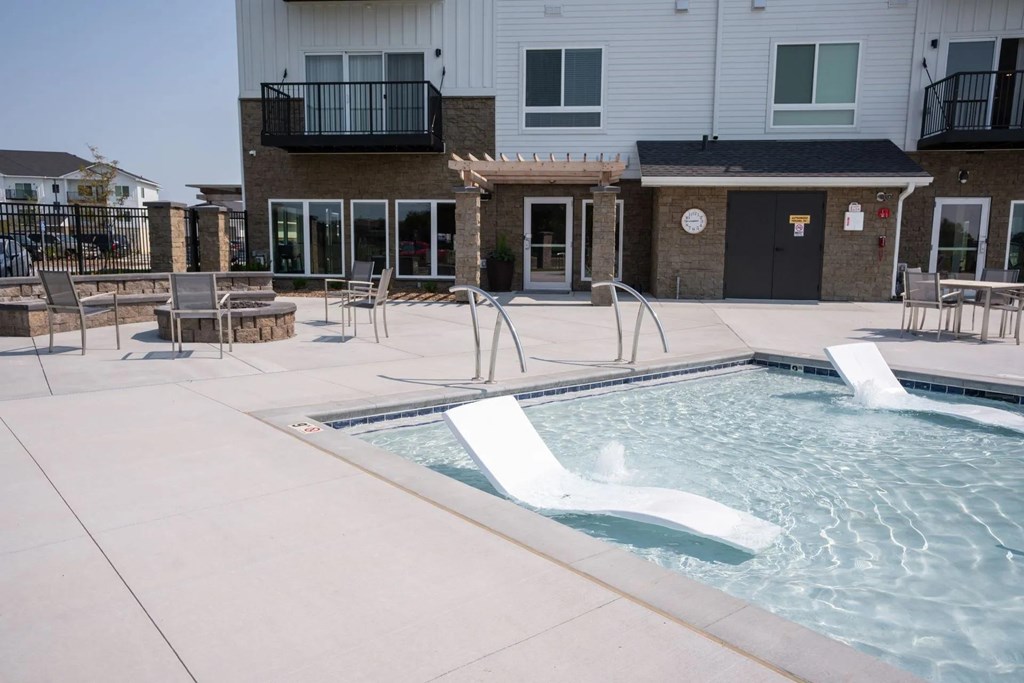 A pool with a slide in front of a building.