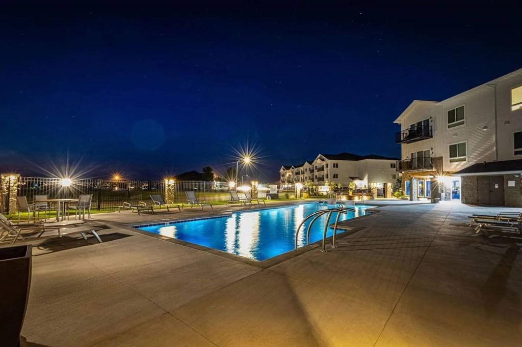 A swimming pool at night with lights reflecting on the water.