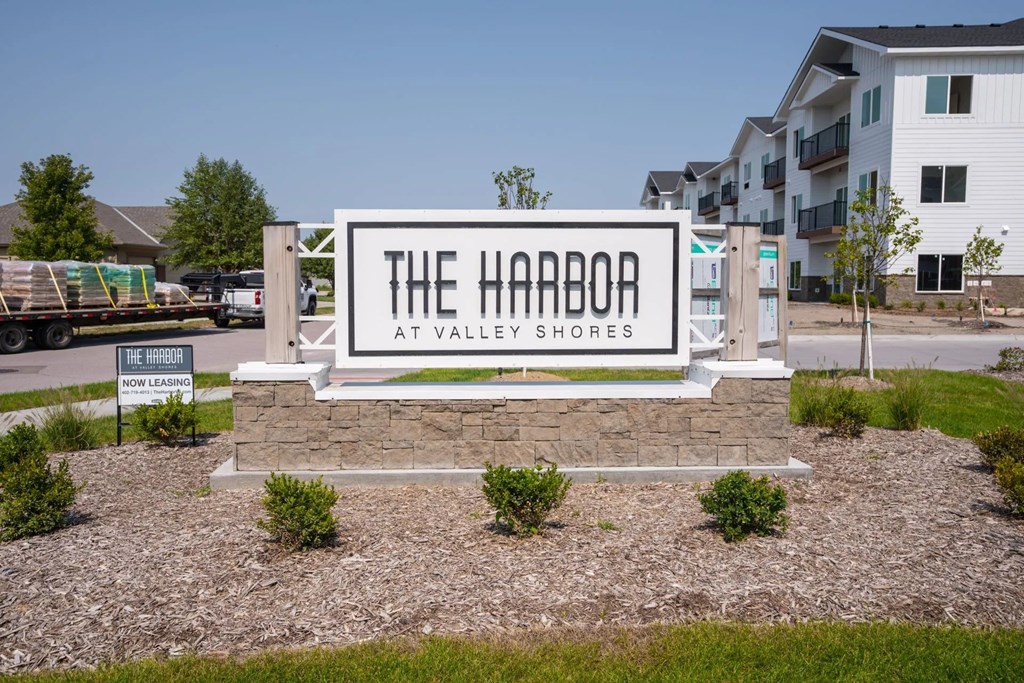 A sign that says "The Harbor at Valley Shores" in front of a building.