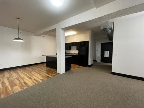A room with a grey carpet and a wooden floor.