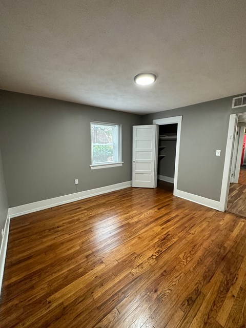 A room with wooden flooring and a window.
