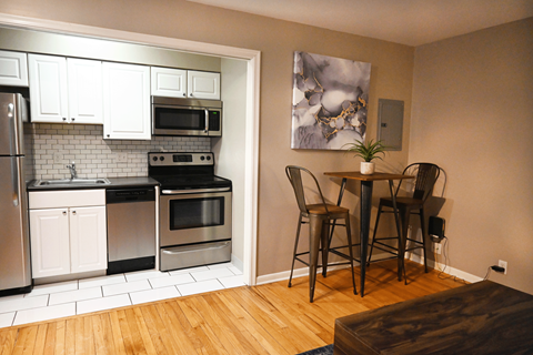 A kitchen with a dining table and chairs.