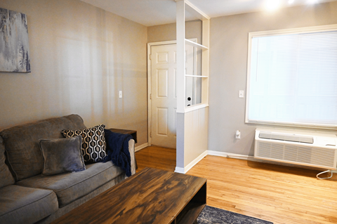 A living room with a grey couch and a wooden coffee table.
