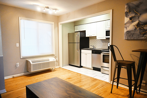 A kitchen with a refrigerator, oven, and microwave.