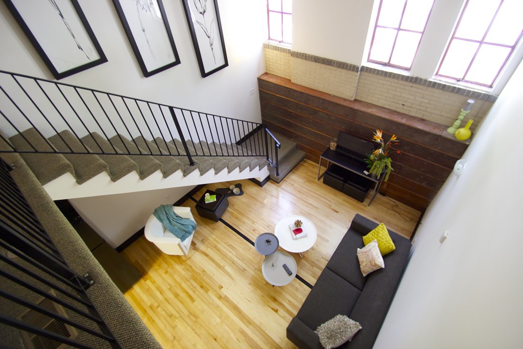 A living room with a couch, coffee table, and a staircase.