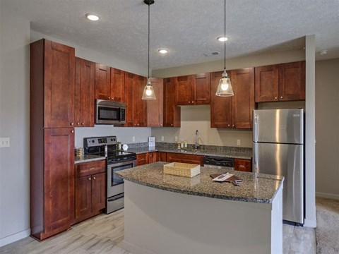 A kitchen with wooden cabinets and a granite countertop.