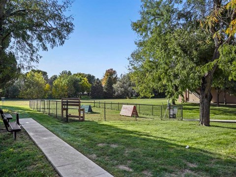 A park with a walking path, benches, and a playground.