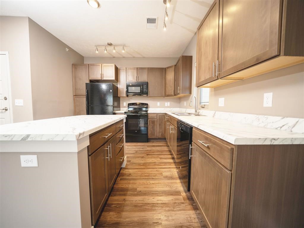 A kitchen with wooden cabinets and a white counter top.