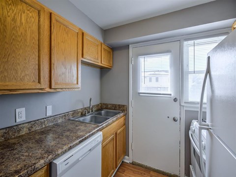 A kitchen with wooden cabinets and a granite countertop.