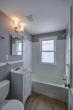 A small bathroom with a toilet, sink, and bathtub.