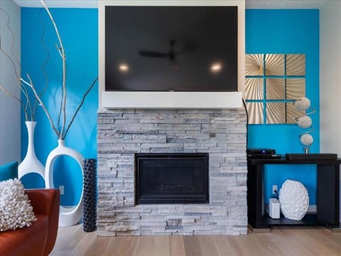 A modern living room with a fireplace and a TV above it.