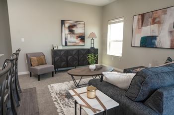 A living room with a grey couch, a brown coffee table, and a grey chair.