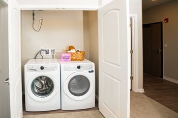Two white front loading washing machines in a small laundry room.