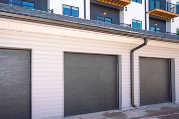 A building with a white facade and a black garage door.