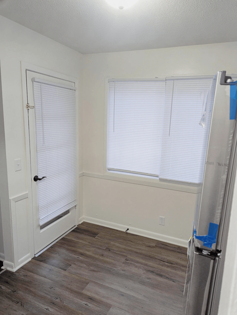 Dining area with wood style flooring window and door at Northbrook Apartments