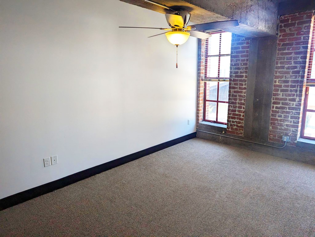 A room with a ceiling fan and a window.
