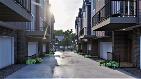 A sunny day in a residential area with apartment buildings on both sides of a paved road.