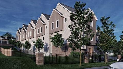A row of houses with a black fence in front.