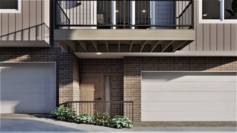 A modern two-story building with a balcony and garage doors.