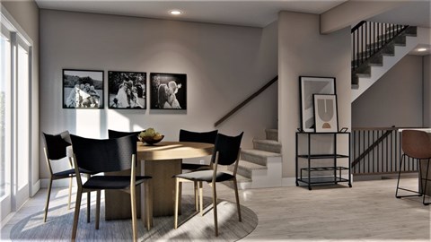 A dining room with a table and chairs and a staircase.