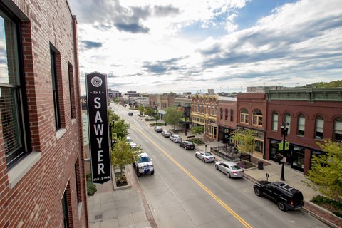 A street view of a city with cars parked on the side of the road.