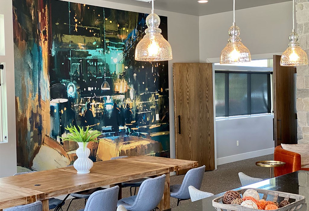 A dining room with a large table and chairs.