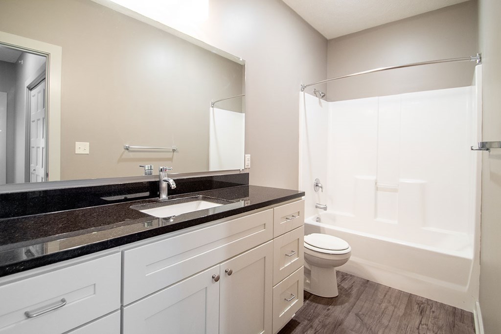 A bathroom with a sink, toilet, and bathtub.