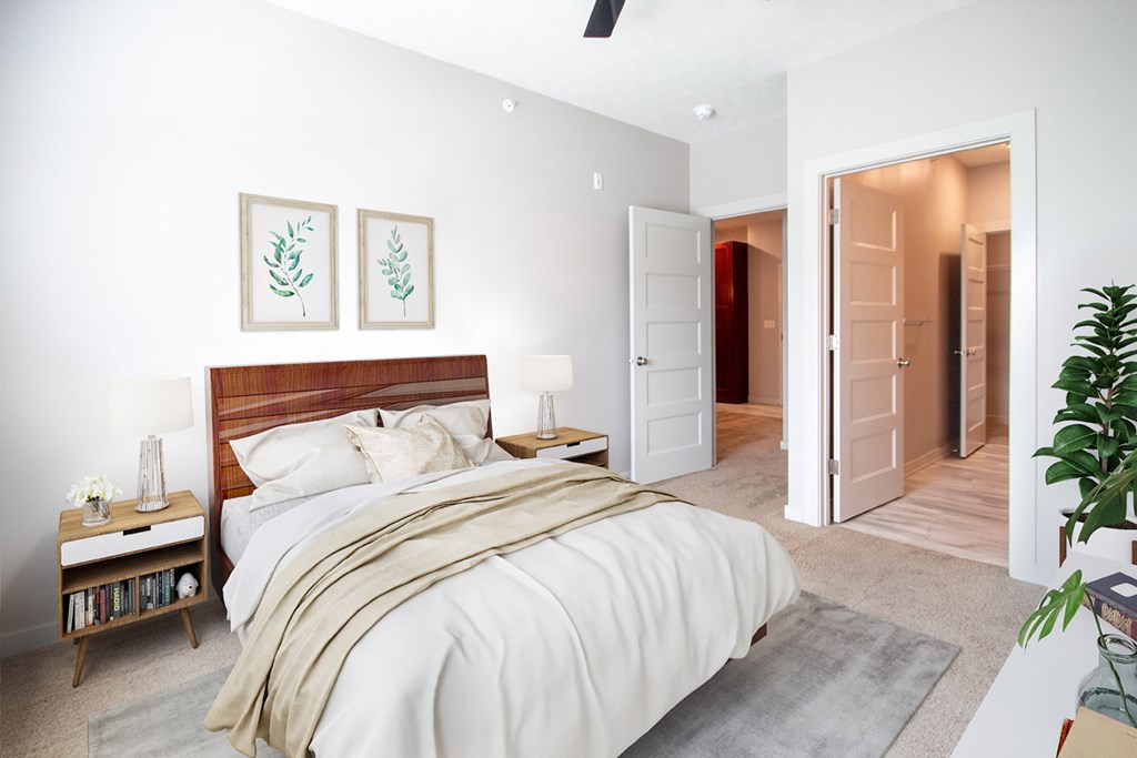 A bedroom with a large bed and a ceiling fan.