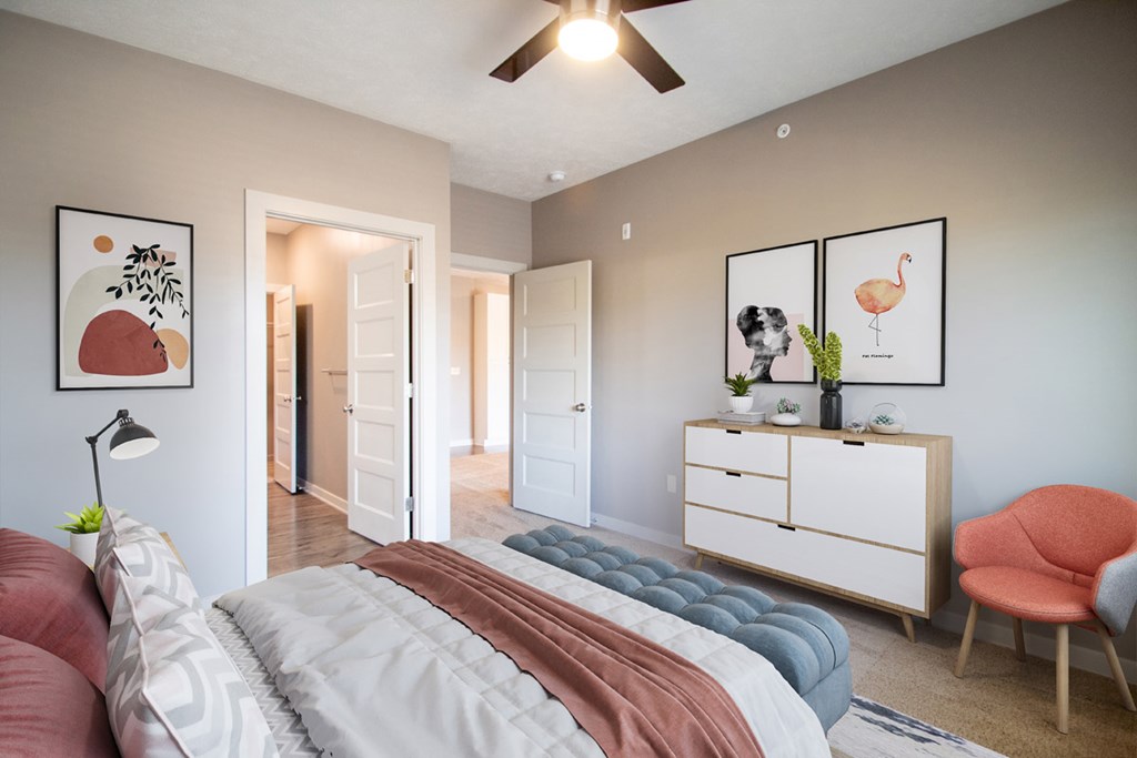 A bedroom with a bed, a chair, and a dresser.