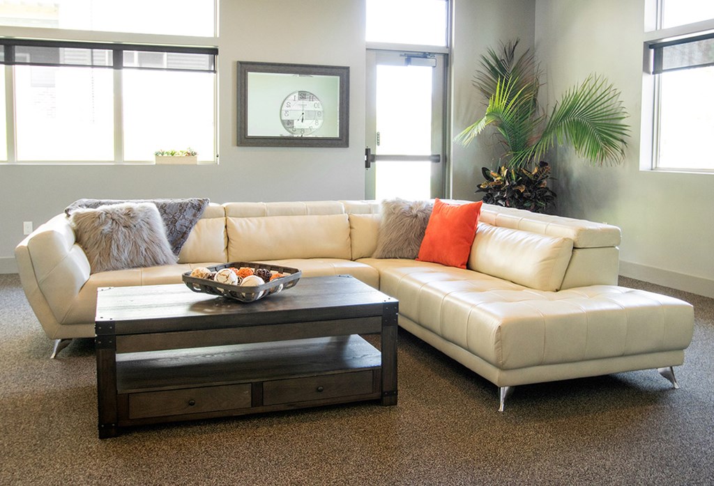A white couch with a coffee table in front of it.