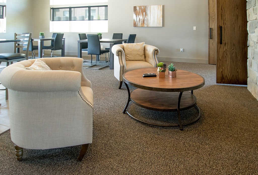 A living room with a white chair and a brown coffee table.