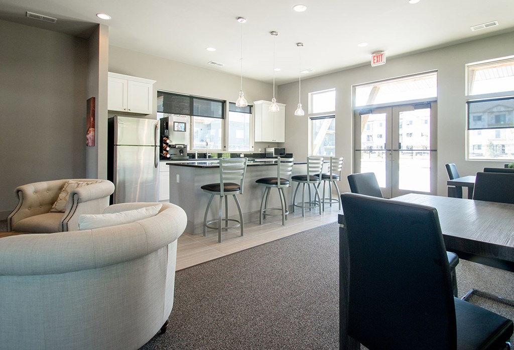 A modern kitchen with a breakfast bar and a dining table.