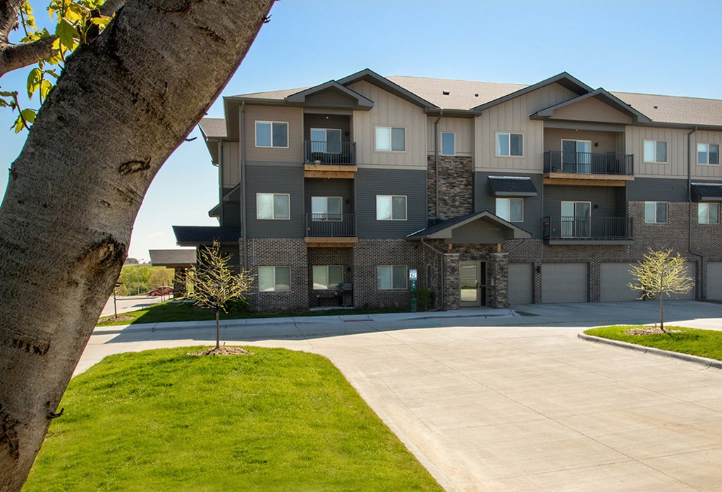 A large apartment building with a tree in the foreground.