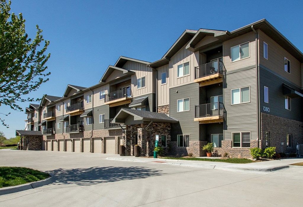 Apartment complex with a parking lot in front.