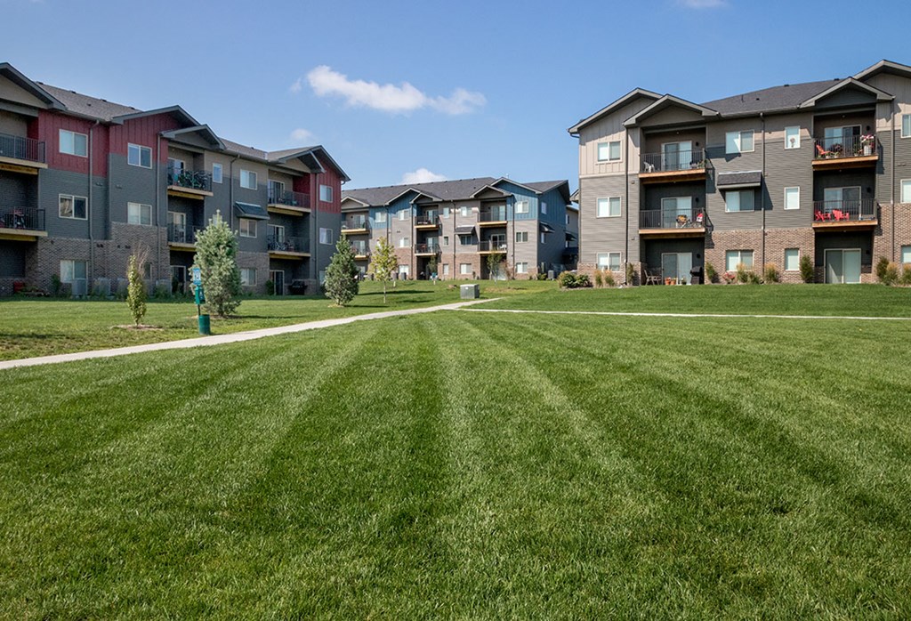 Apartment buildings with green lawns in front.