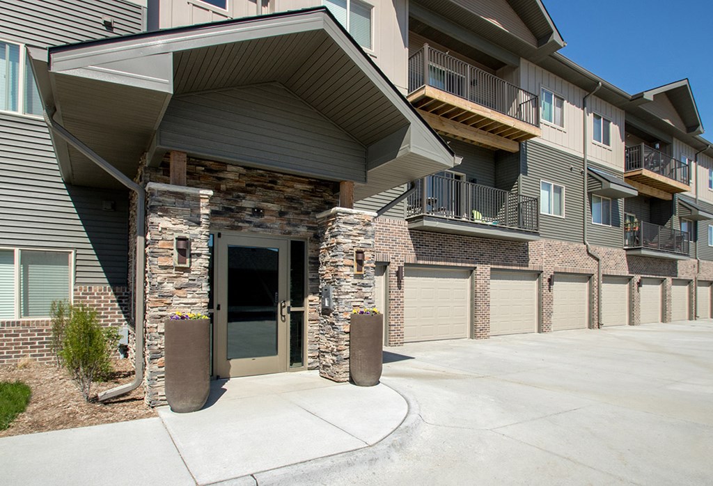 A modern apartment building with a stone pillar entrance.