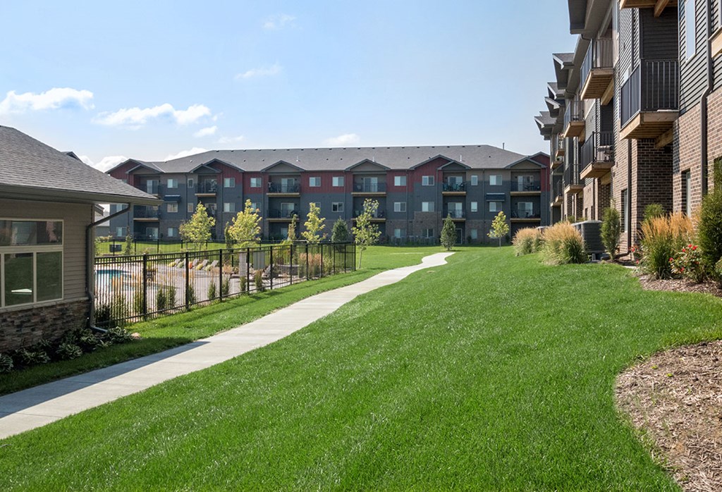 A grassy area in front of apartment buildings.