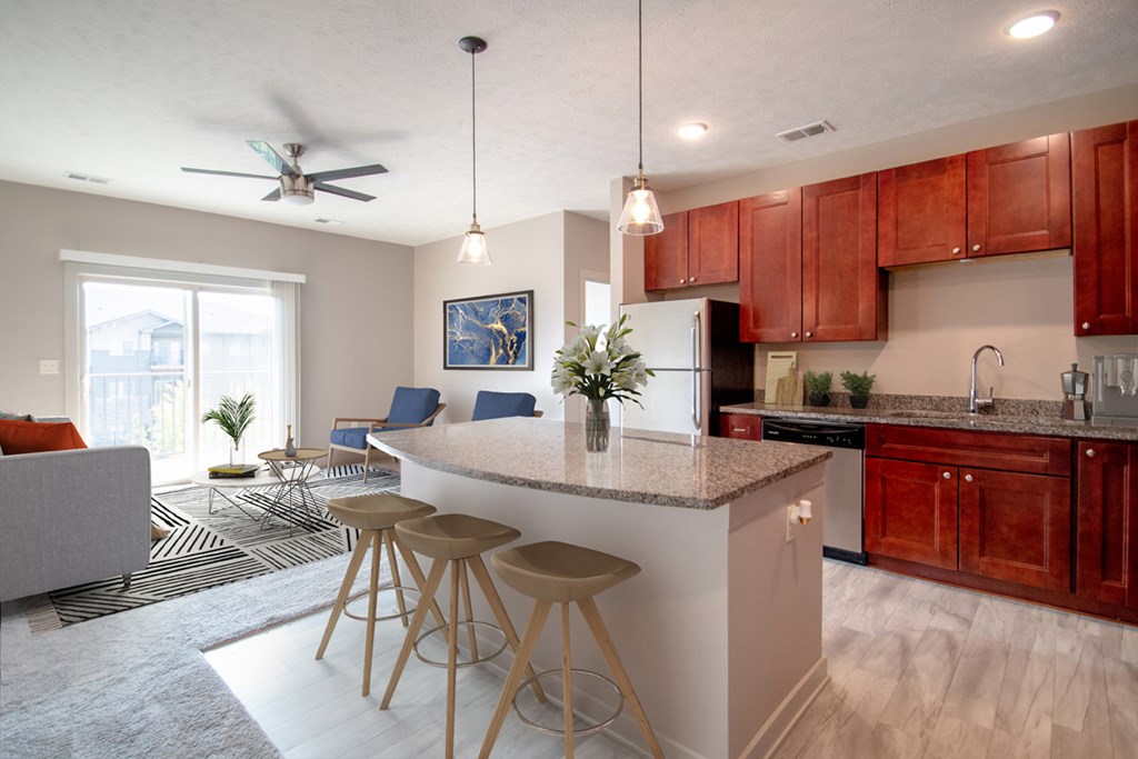 A kitchen with a white island and wooden bar stools.