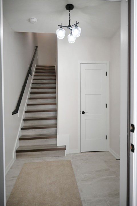 A hallway with a staircase and a door.