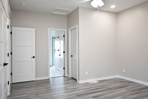 A room with a white door and a grey floor.