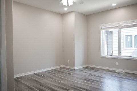 A room with a window and a wooden floor.