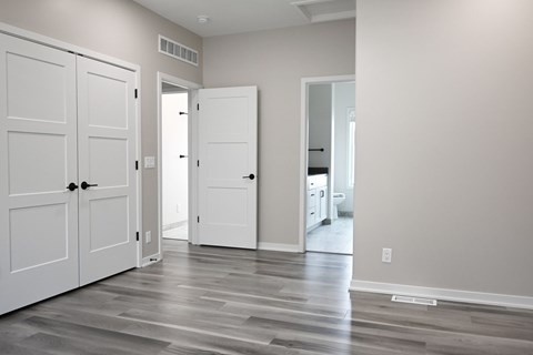 A room with white doors and a grey floor.