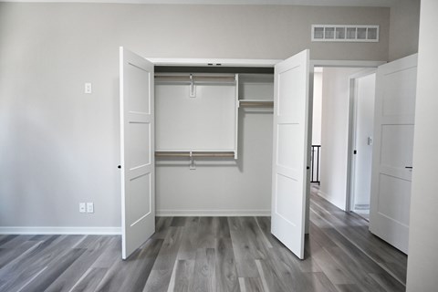 A room with a white door and a grey floor.