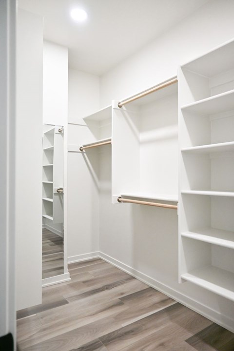 A hallway with a white wall and shelves.