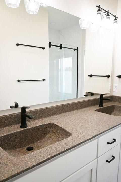 A bathroom with two sinks and a large mirror.