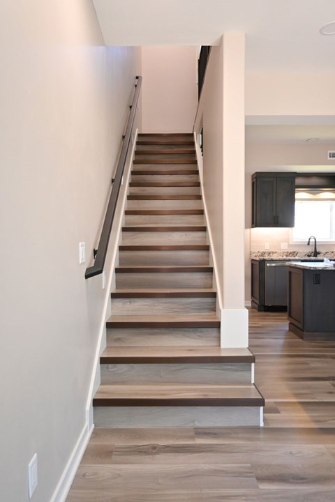 A staircase with wooden steps and a metal handrail.