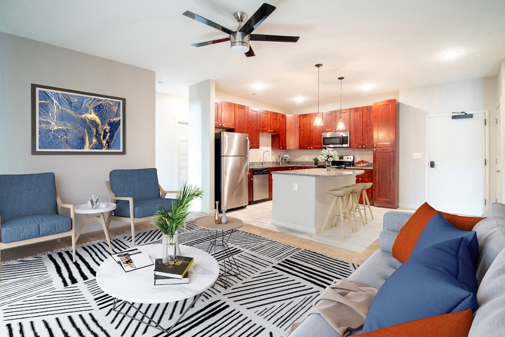 A living room with a black and white striped rug, a blue couch, and a painting on the wall.